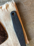 (Detail of the forged black stainless handle showing texture and maker's mark.)