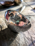 (Close-up of a polished hammered stainless steel bowl riveted with copper, hand-forged in Quebec.)