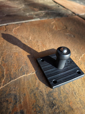 Angled close-up of a handcrafted carbon steel single peg hook and wax-sealed black forge finish, made at Strobus Forge.