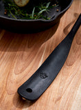 closeup of hand forged serving spoon handle showing forged texture and embossed logo