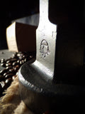 partial closeup of hand forged tamper showing forged texture and embossed logo